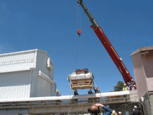 The 2-ton APOGEE instrument is lowered to the concrete pad in front of its room in the warm building next to the telescope at Apache Point Observatory.