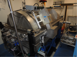  The APOGEE-South instrument in its dedicated room at the du Pont Telescope at Las Campanas.  The room was previously the darkroom used for the processing of photographic plates.  The instrument sits on a base-isolation system that mitigates motion during earthquakes. <em>Photo courtesy of J. Wilson.</em>“></a></div>
<div class=